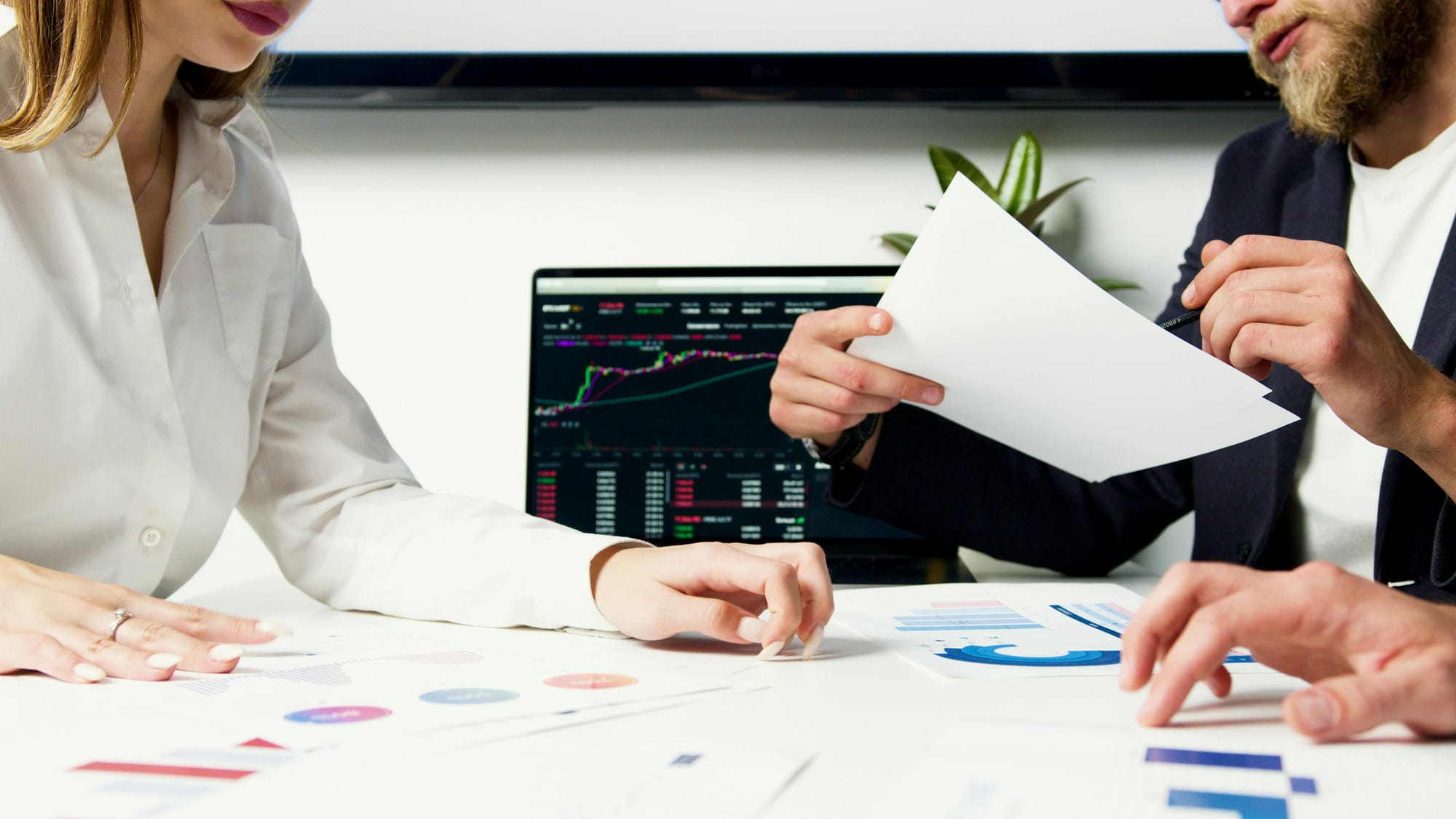 Man and woman in a business meeting exchanging papers 