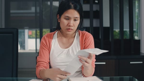 Woman looking at her bill looking stressed 