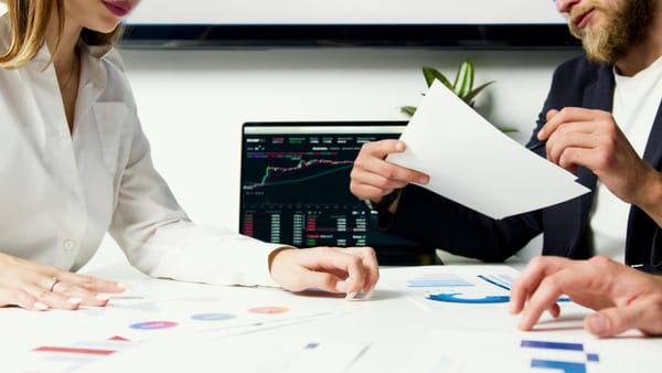 Man and woman in a business meeting exchanging papers 